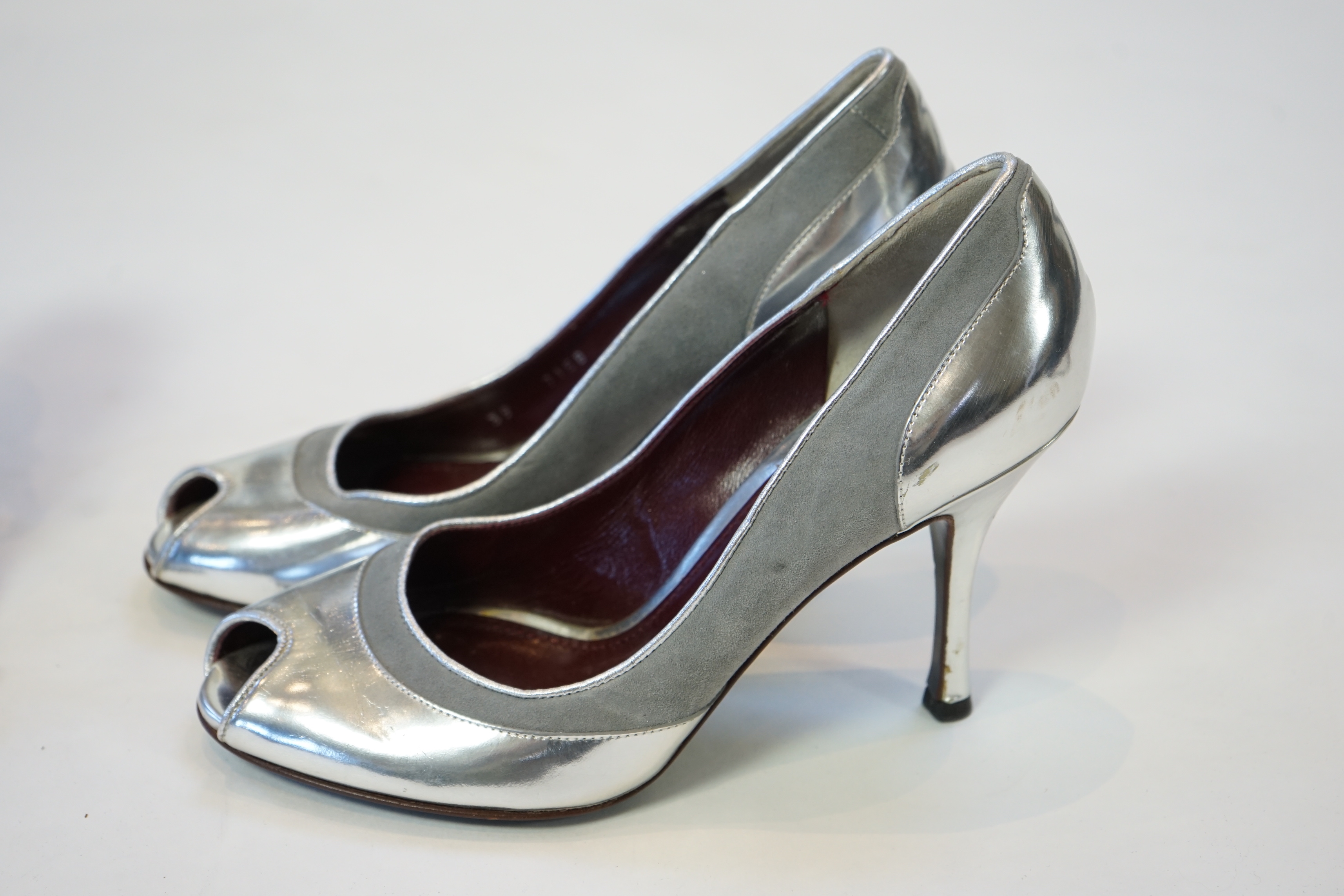 A pair of Fendi lady's metallic silver sandals with three diamante circle detail and a pair of Dolce and Gabbana silver patent leather and suede peep toe heels, size EU 39/40